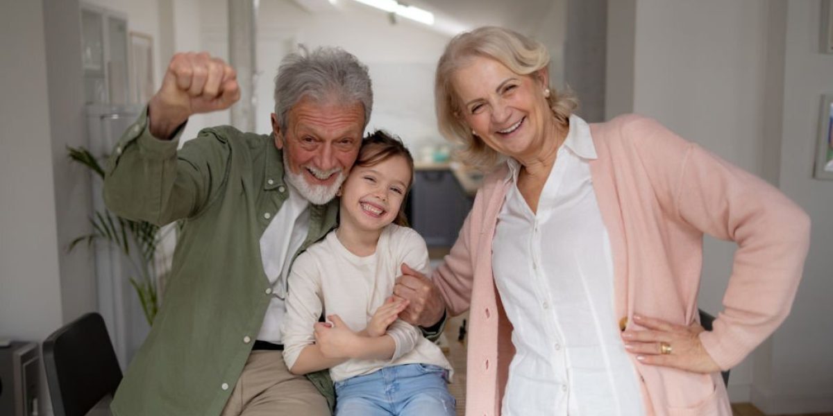 Portrait of a cheerful Caucasian little girl at home bonding with her grandparents and having fun together, smiling and laughing